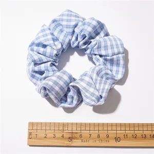 Dettaglio dell'elastico per capelli a scacchi bianchi e blu con trama del tessuto e 10 cm