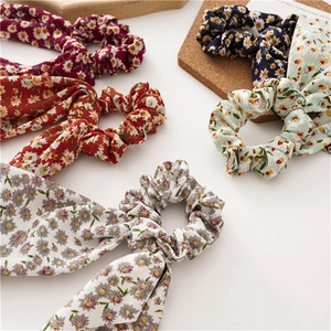 Flat lay of floral hair scrunchies with long streamers and butterfly bow details