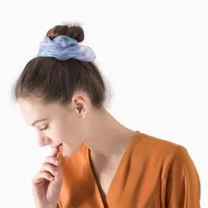Close-up of iridescent purple organza scrunchie styled on a bun hairstyle