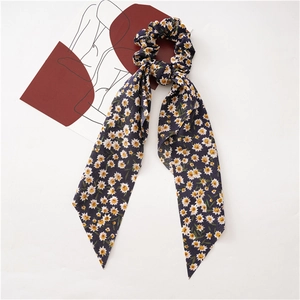 Detail showing the floral daisy pattern on blue chiffon ribbon scrunchie accessory
