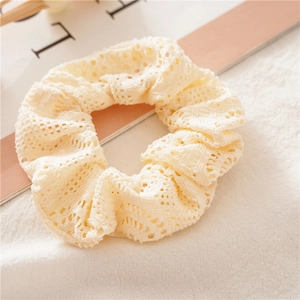 Nahaufnahme des cremefarbenen Spitzen-Scrunchies mit filigranen Häkelblumen-Details