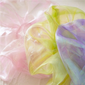 Close-up of iridescent organza scrunchies in pink, yellow and purple pastel colors