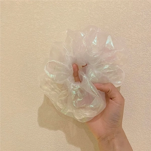 Close-up of iridescent organza scrunchie with pearlescent mermaid glow and soft ruffles