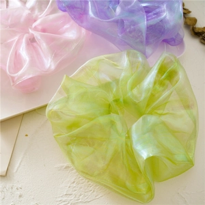 Detailed texture of iridescent organza scrunchies in pastel green, pink and violet