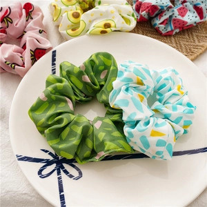 Detailed close-up of fruit pattern scrunchies including strawberry and avocado designs