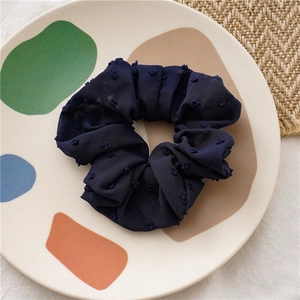 Close-up of navy blue seersucker scrunchie with tiny 3D pom-pom floral textures