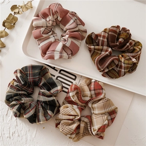 Gros plan de quatre chouchous en tissu à carreaux de couleurs variées sur un plateau