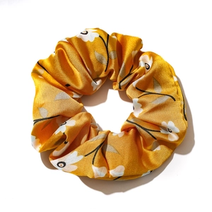Yellow floral satin scrunchie with a retro elegant pattern on a clean white background