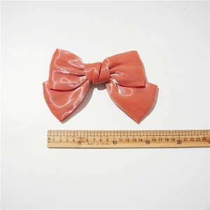 Mesure détaillée d'une pince à cheveux nœud orange corail de 16,5 cm sur fond blanc