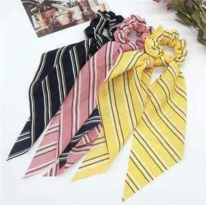 Detailed view of striped chiffon bow scrunchies in navy, pink, and yellow colors