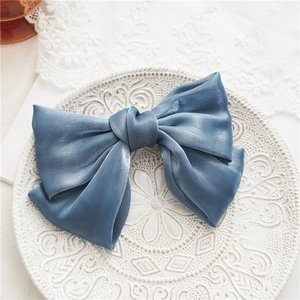 Détail de la pince à cheveux en tulle bleu double couche avec noeud central sur porcelaine