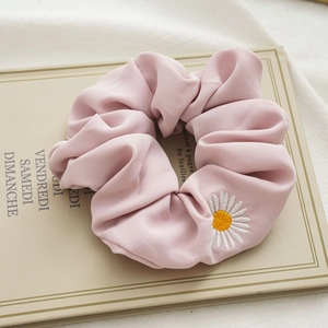Primo piano dettagliato di un elastico in raso rosa con elegante ricamo a margherita