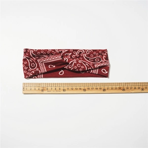 Elastic knot headband with burgundy paisley pattern for women in minimalist style