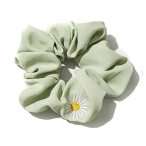 Elastico per capelli in raso verde menta con ricamo a margherita su sfondo bianco