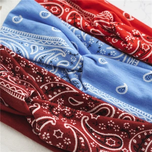Close-up of three knot wide headbands with paisley pattern in red, blue, and burgundy