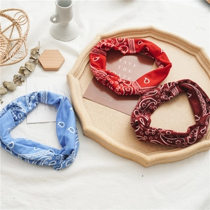 Detailed view of red and blue paisley knotted headbands on a decorative tray