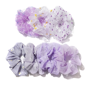7er Set lila Haargummis mit Gänseblümchen-Print und Pailletten auf weißem Grund