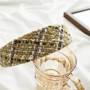 Close-up of yellow and grey tweed woven texture on a padded vintage-style headband