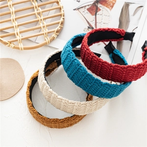 Close-up of handmade knitted headbands showing detailed vertical weave and vintage textures
