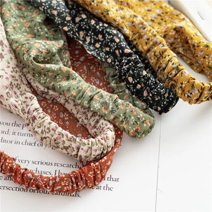 Detail showing elastic floral headbands in yellow, green and cream on a magazine page