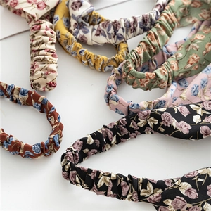 Close-up of assorted vintage floral headbands with twisted knot design in multiple colors