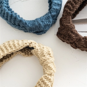 Détail de bandeaux tricotés à nœuds montrant une texture épaisse en bleu, brun et beige