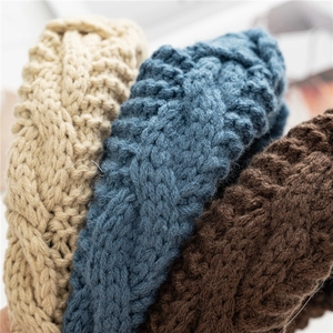 Gros plan de bandeaux en grosse maille beige, bleu et marron avec texture torsadée