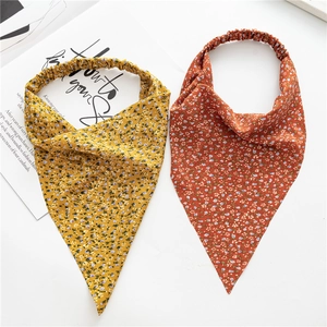 Detail view of floral triangle headbands in yellow and rust red with elastic band