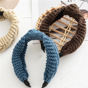 Détails de trois bandeaux larges en maille torsadée coloris bleu, marron et beige clair