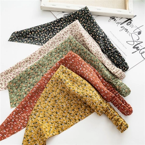 Detail view of five floral print elastic bandanas in black beige green red and yellow
