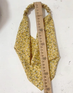 Detail showing measurement of yellow floral elastic headscarf with wooden ruler