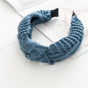 Détail du bandeau tricoté bleu avec un design à nœud large et une texture côtelée