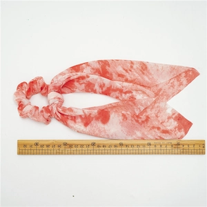 Detail view of red tie-dye scrunchie scarf with measuring ruler for size reference