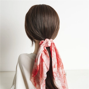 Pink and red tie-dye scrunchie scarf tied on a ponytail with elegant hanging streamers