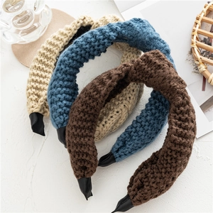 Trois serre-têtes en maille nouée en beige, bleu et marron sur fond blanc épuré