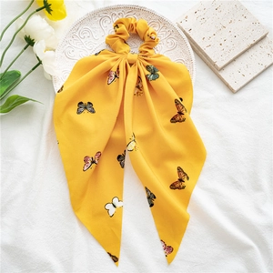 Close-up of yellow chiffon scrunchie with colorful butterfly prints and long streamer