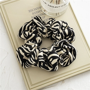Detail of zebra stripe fabric scrunchie with elastic texture on minimalist display board