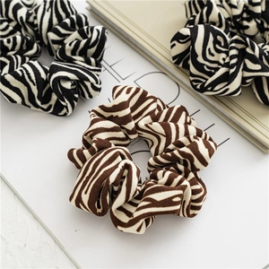 Close-up of zebra pattern knitted scrunchies set on minimalist background