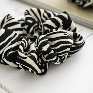 Close-up detail of stylish zebra print scrunchie with soft ribbed fabric texture