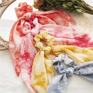 Tie-dye scrunchie scarves in coral, pink and blue chiffon on a vintage table