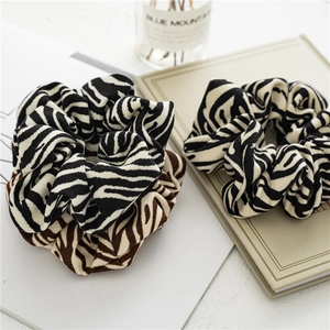 Detail view of zebra stripe scrunchies in black and brown with soft knit texture