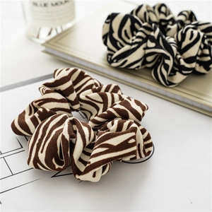 Detailed view of soft zebra striped scrunchies in brown and black on a desk