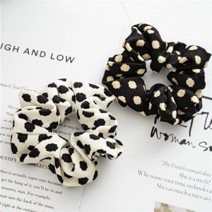 Close-up of black and white polka dot pattern fabric scrunchies on a magazine page