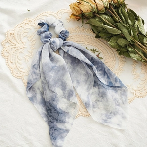 Detailed view of blue and white tie-dye hair scrunchie scarf with long flowing ribbon