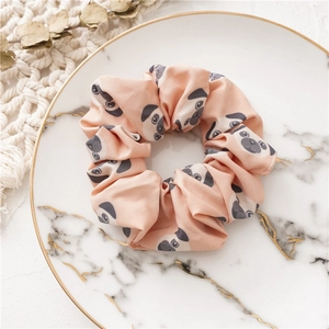 Roze scrunchie met cartoon mopshond patroon op een marmeren bord decoratie
