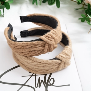 Détail du bandeau tricoté camel montrant la texture de la maille torsadée et la doublure