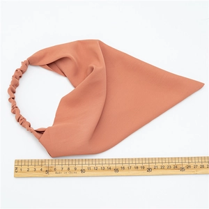 Detail of macaron color elastic headband showing brick red fabric texture and size scale