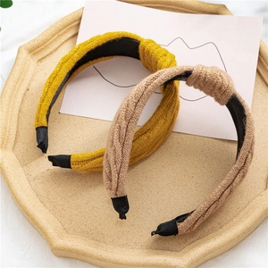 Détail de bandeaux noués en tricot jaune et marron avec une texture tressée épaisse