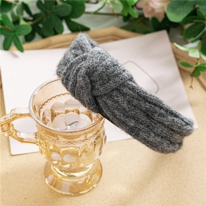 Détail d'un bandeau en maille gris foncé avec nœud central et texture en laine douce