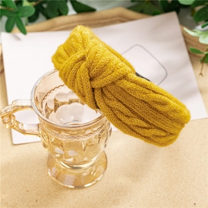 Gros plan d'un bandeau en maille jaune vif avec un détail de nœud torsadé